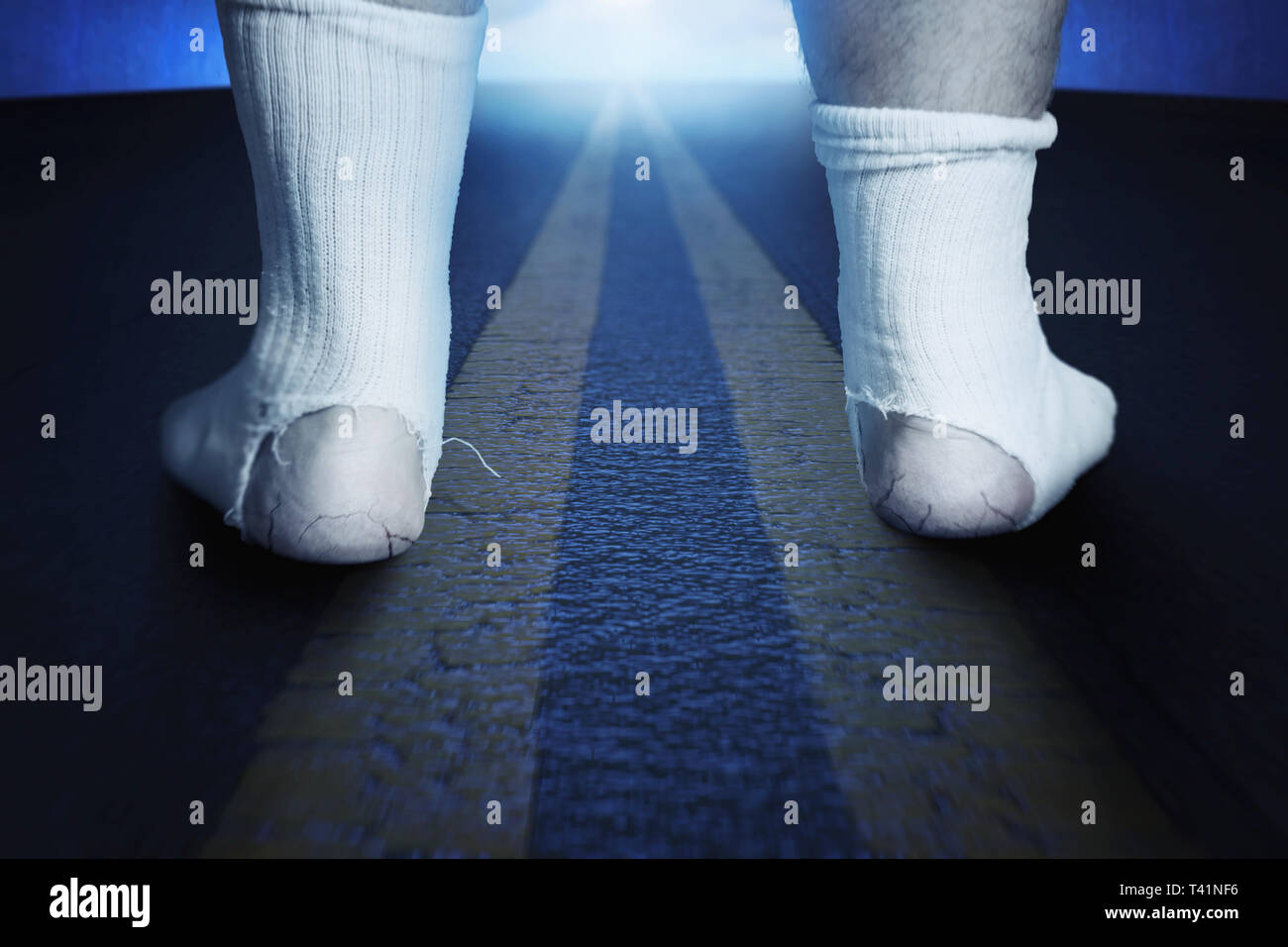 back of standing feet with white socks and a big hole standing on asphalt at night Stock Photo