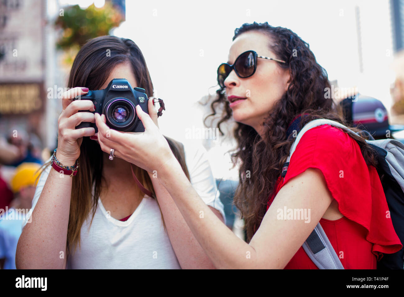 Women photographers on a crowded street take pictures with a camera Stock Photo