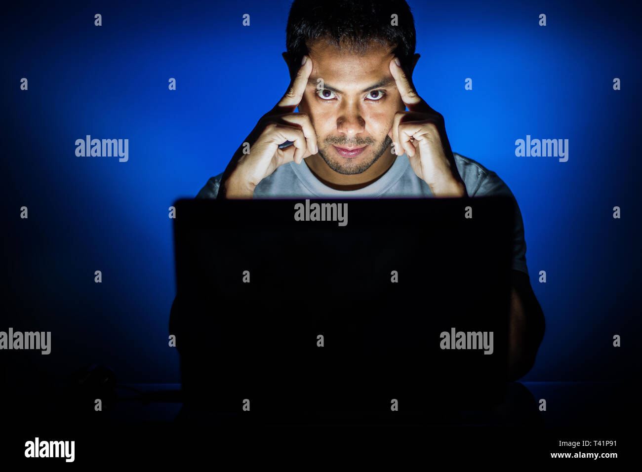 Man thinking in the computer with blue background Stock Photo