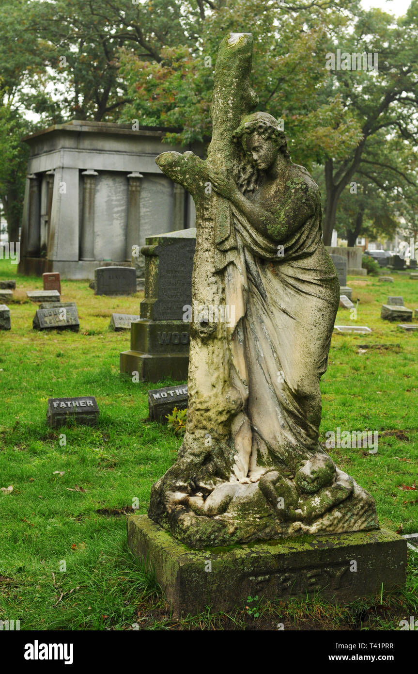A sculpture of a woman and infant mark a grave at the historic Oakhill Cemetery in Grand Rapids, Michigan. The cemetery dates from the 1850s. Stock Photo
