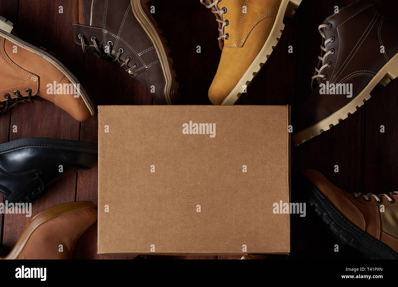 Leather footwear theme. Cartoon box for shoes on wooden background Stock Photo