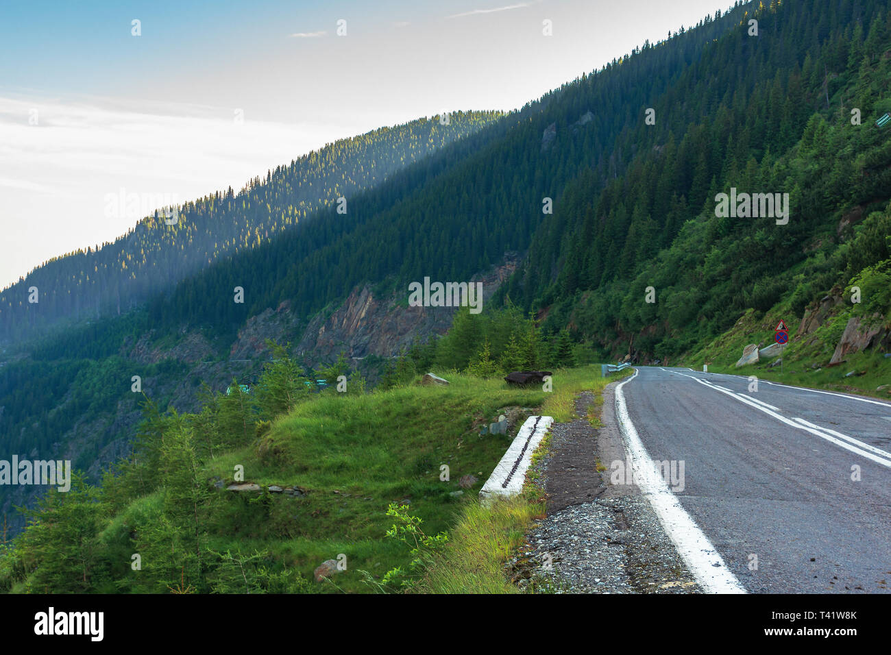transfagarasan road at sunrise. popular travel destination of romania. beautiful summer landscape in mountains. road winding through gorge with steep  Stock Photo