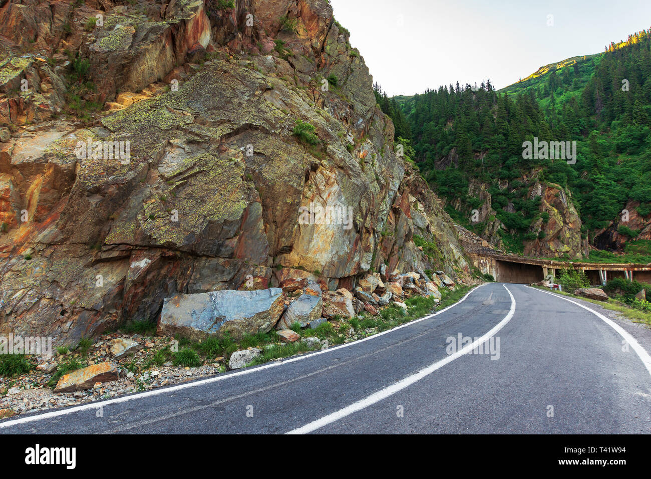 transfagarasan road at sunrise. popular travel destination of romania. beautiful summer landscape in mountains. road winding uphill through gorge with Stock Photo