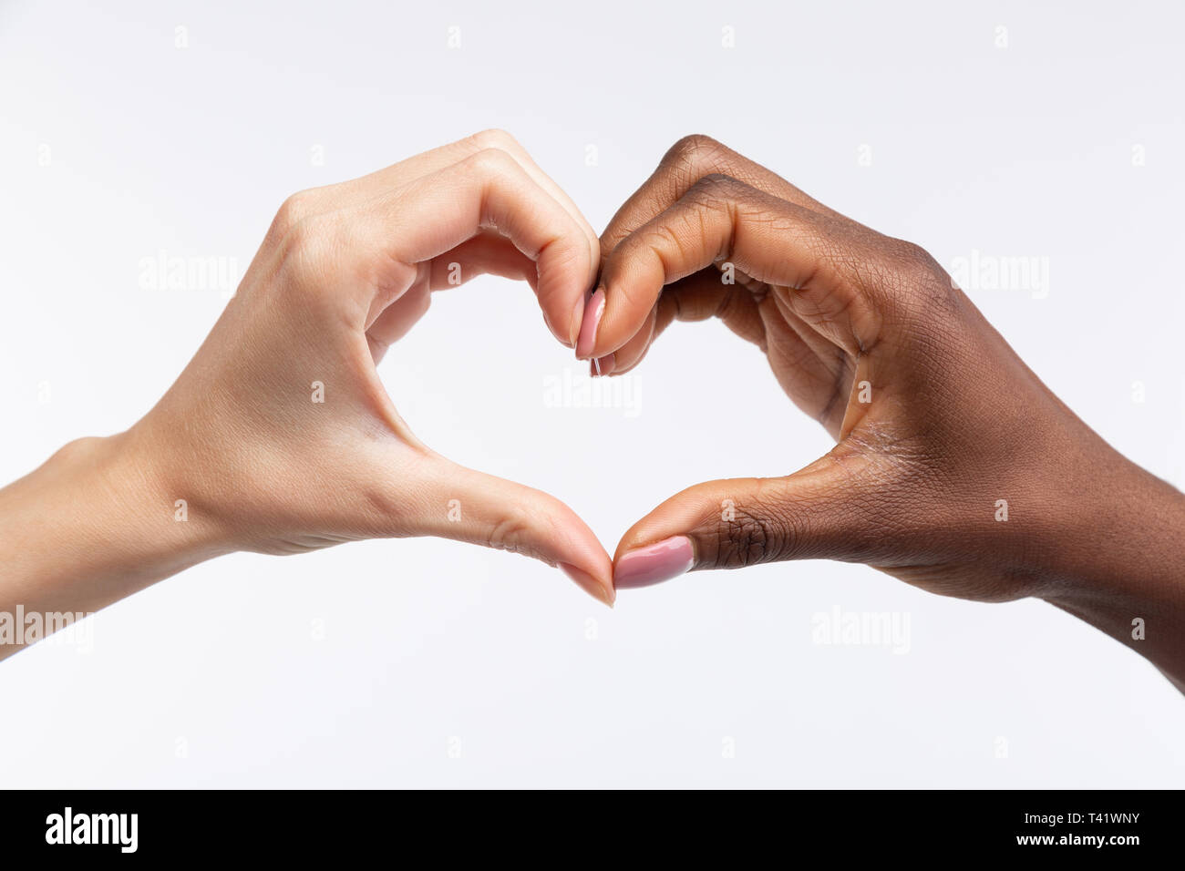 Women with white and black skin showing heart with their hands Stock Photo