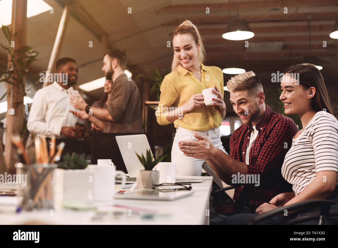 Colleagues working on project, using laptop at workplace Stock Photo