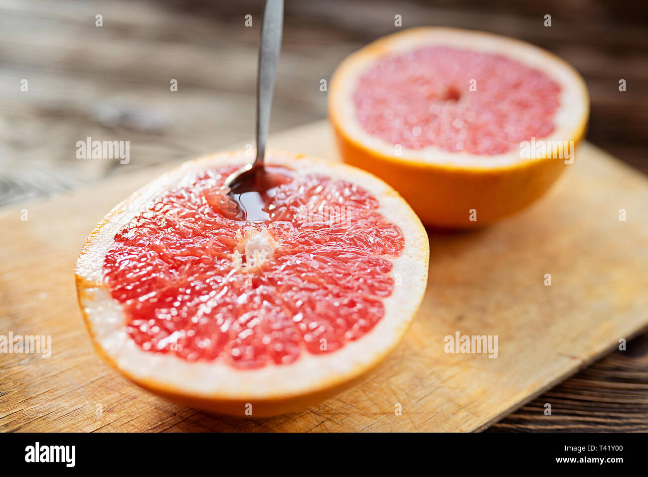 Fresh juicy half a grapefruit with a spoon. Morning light Stock Photo