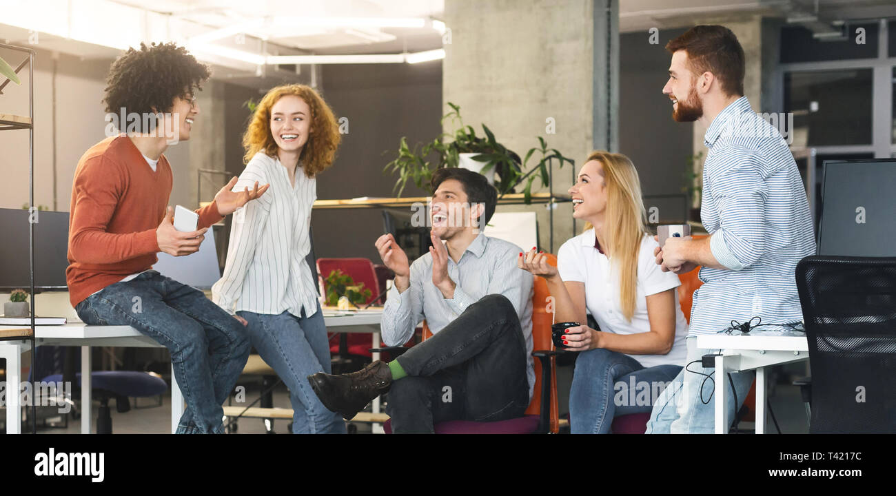 Diverse millennial people having good talk at coworking space Stock Photo