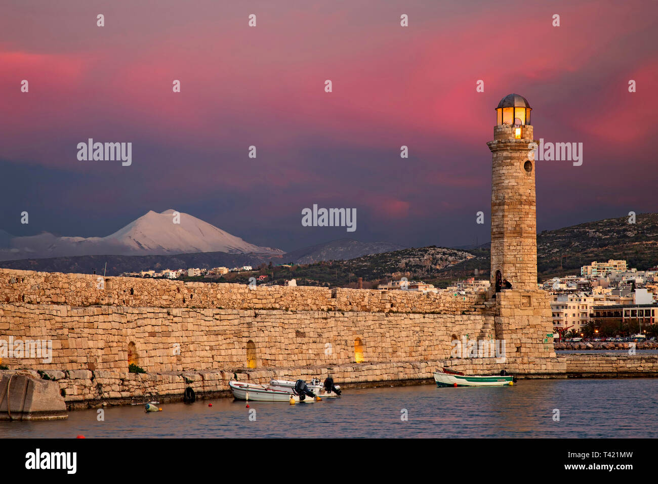 The beautiful lighthouse at the old port of Rethimno town, Crete, Greece. In the background, Psiloritis mountain. Stock Photo