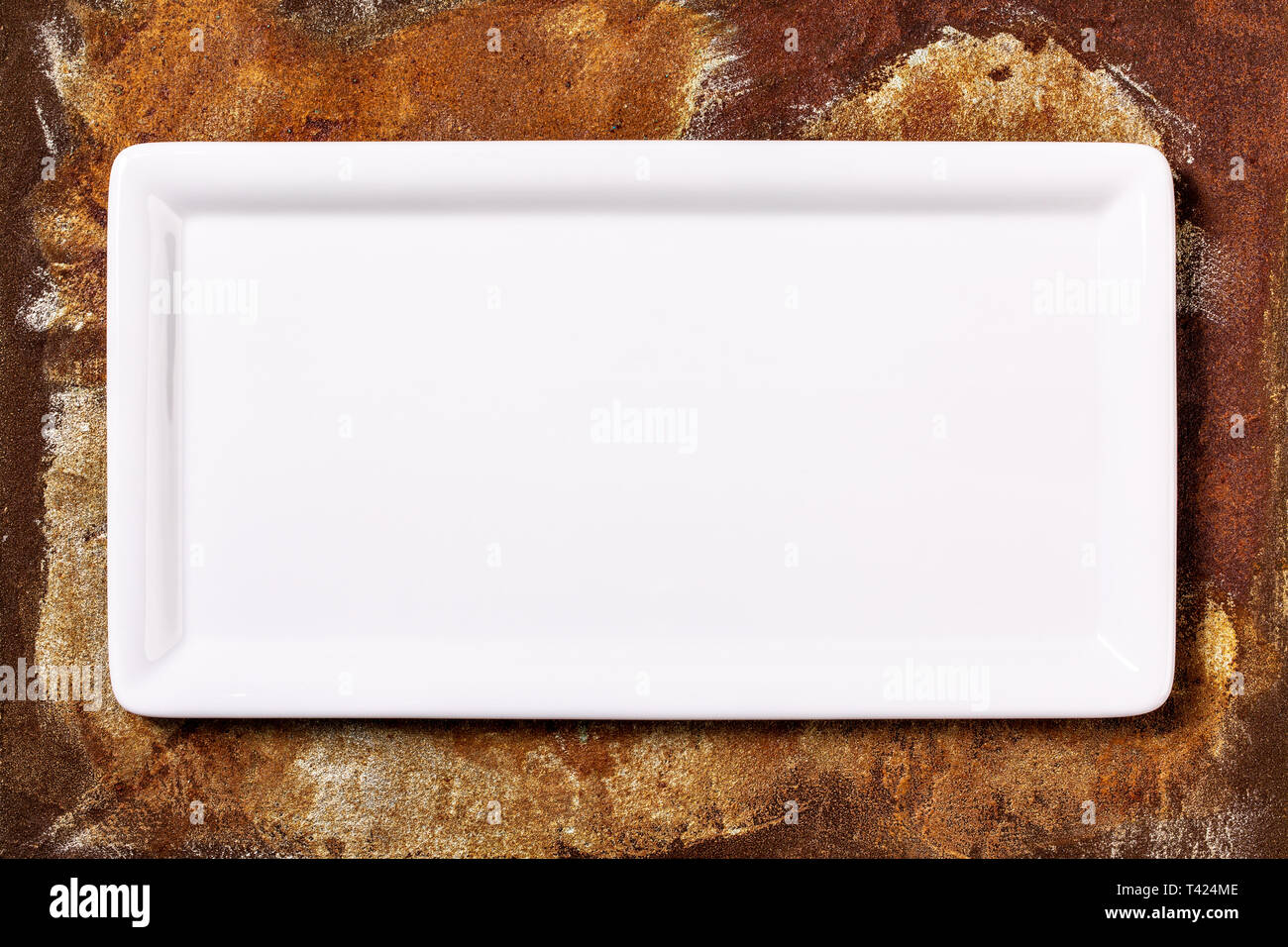Empty white cornered plate on rusted metal background, top view Stock Photo
