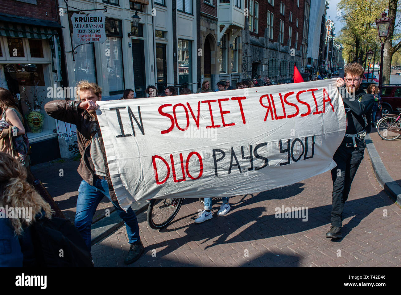 Amsterdam, North Holland, Netherlands. 12th Apr, 2019. Two men are seen  holding a big banner during the demonstration.Around hundred students  gathered at the UVA (The University of Amsterdam) to demonstrate with a