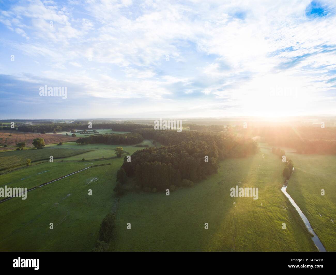 Aerial view of a beautiful sunset over forest landscape with green ...