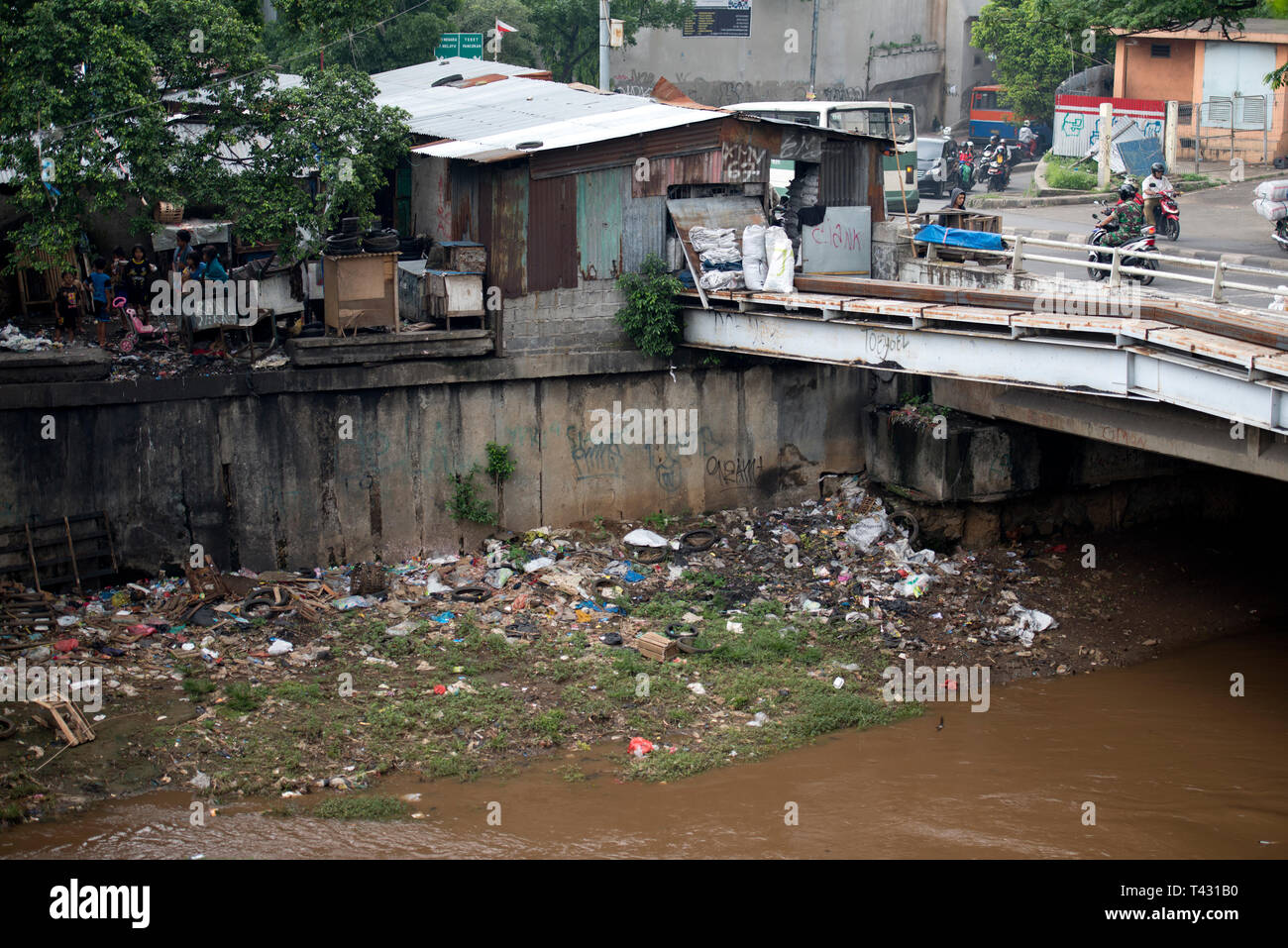 Jakarta pollution, bridge over river with rubbish on bank, Manggarai district, Jakarta