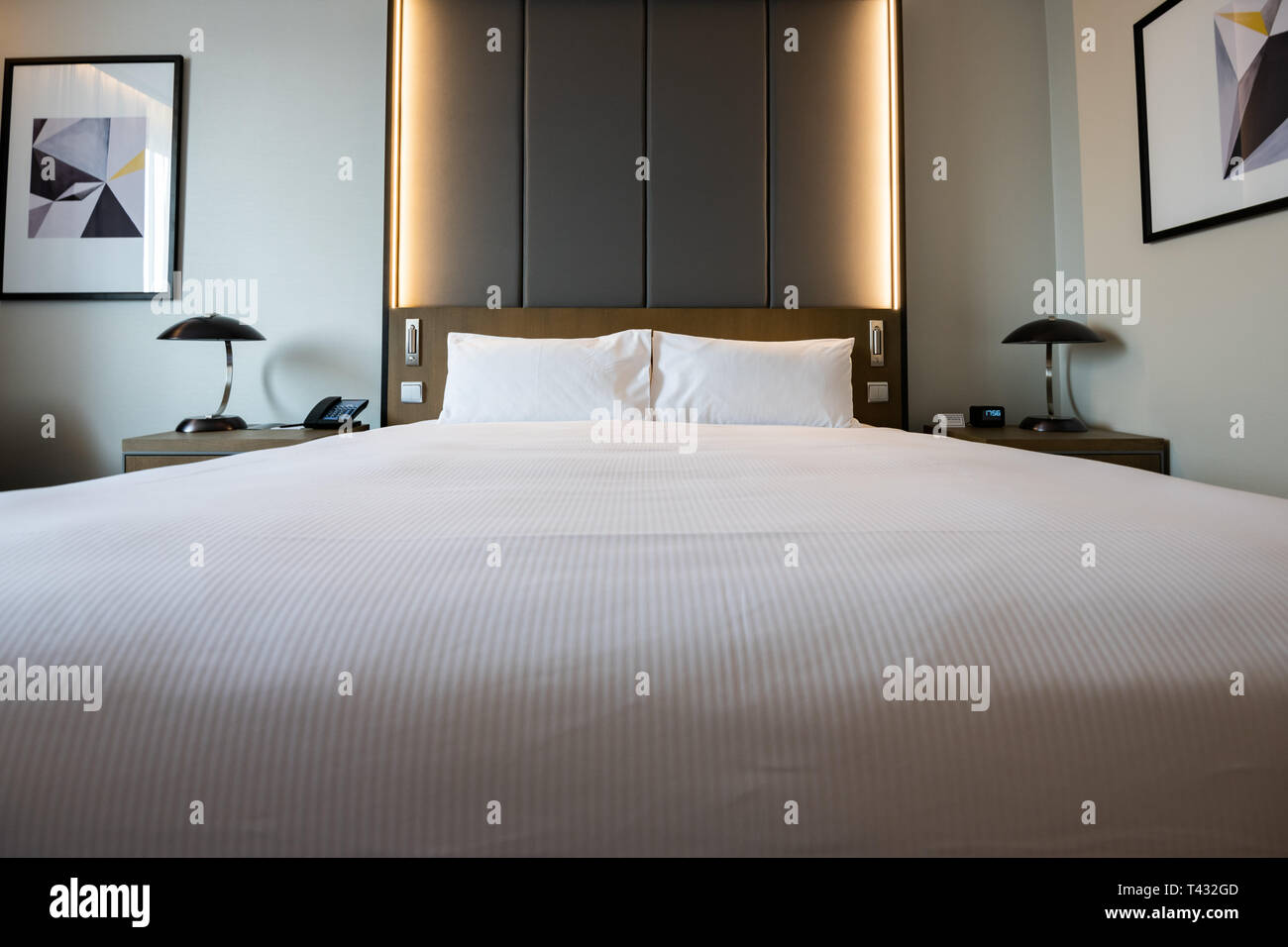 Pictures of a generic hotel room - Bed, window, table, lamps all in shot. Stock Photo