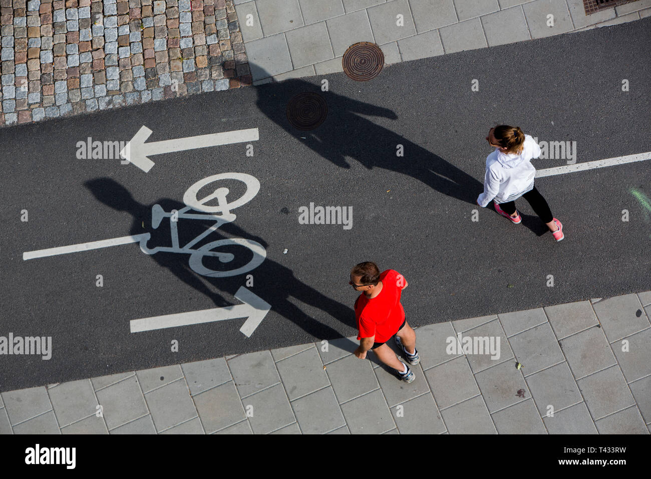 A couple cross a bicycle path, Gothenburg, Sweden. Stock Photo