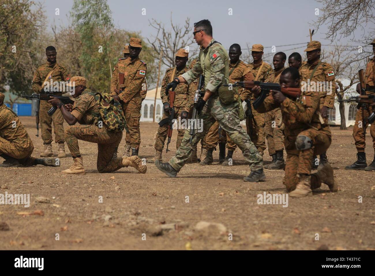 A Portuguese Special Forces soldiers coaches Burkina Faso soldiers during a battle movement training lane on base camp Loumbila, in Burkina Faso on Feb. 21, 2019. The training event enhances the Burkinabe forces abilities to defend, fight, and protect the countries national interest and populace. Stock Photo