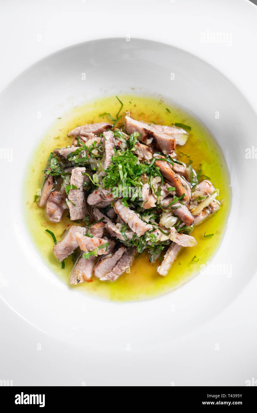 marinated pork with garlic and coriander olive oil sauce gourmet tapas dish Stock Photo