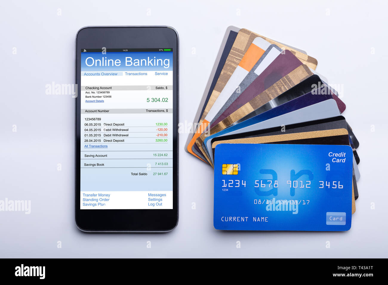 An Overhead View Of Mobilephone With Online Banking App And Credit Cards On White Desk Stock Photo