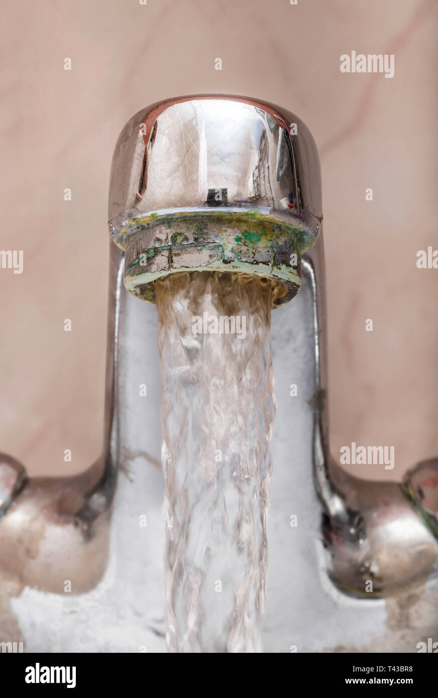 Vertical macro image of a tap with water flowing strongly under high pressure Stock Photo