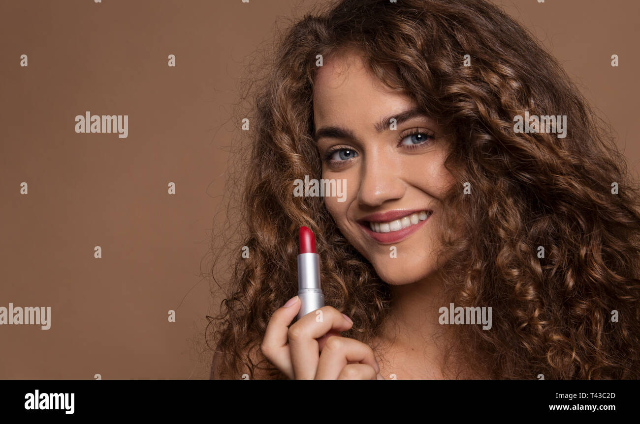 Portrait of a young woman with red lipstick in a studio. Copy space. Stock Photo