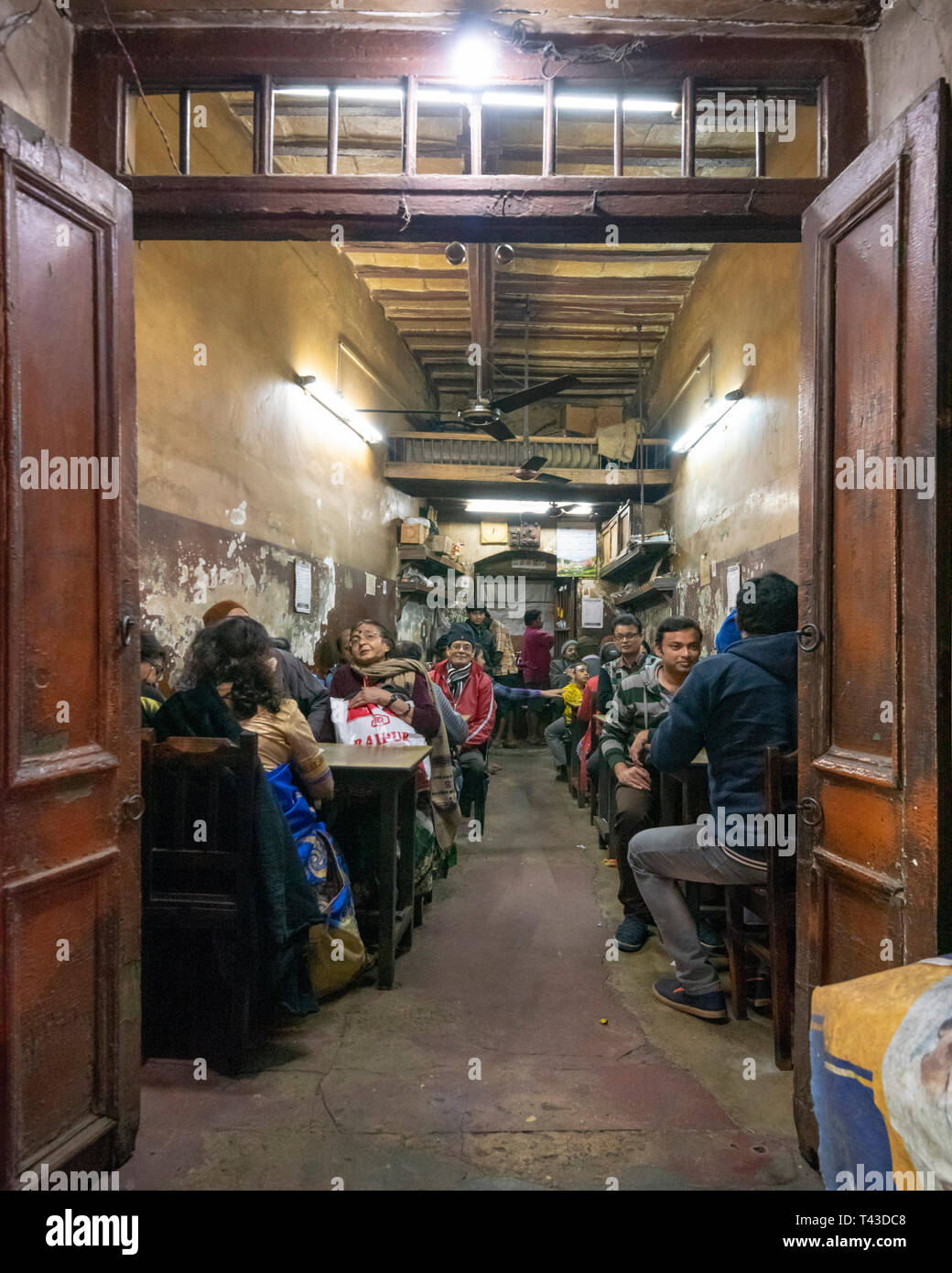 Vertical view local people eating in a ramshackled restaurant in Kolkata aka Calcutta, India. Stock Photo