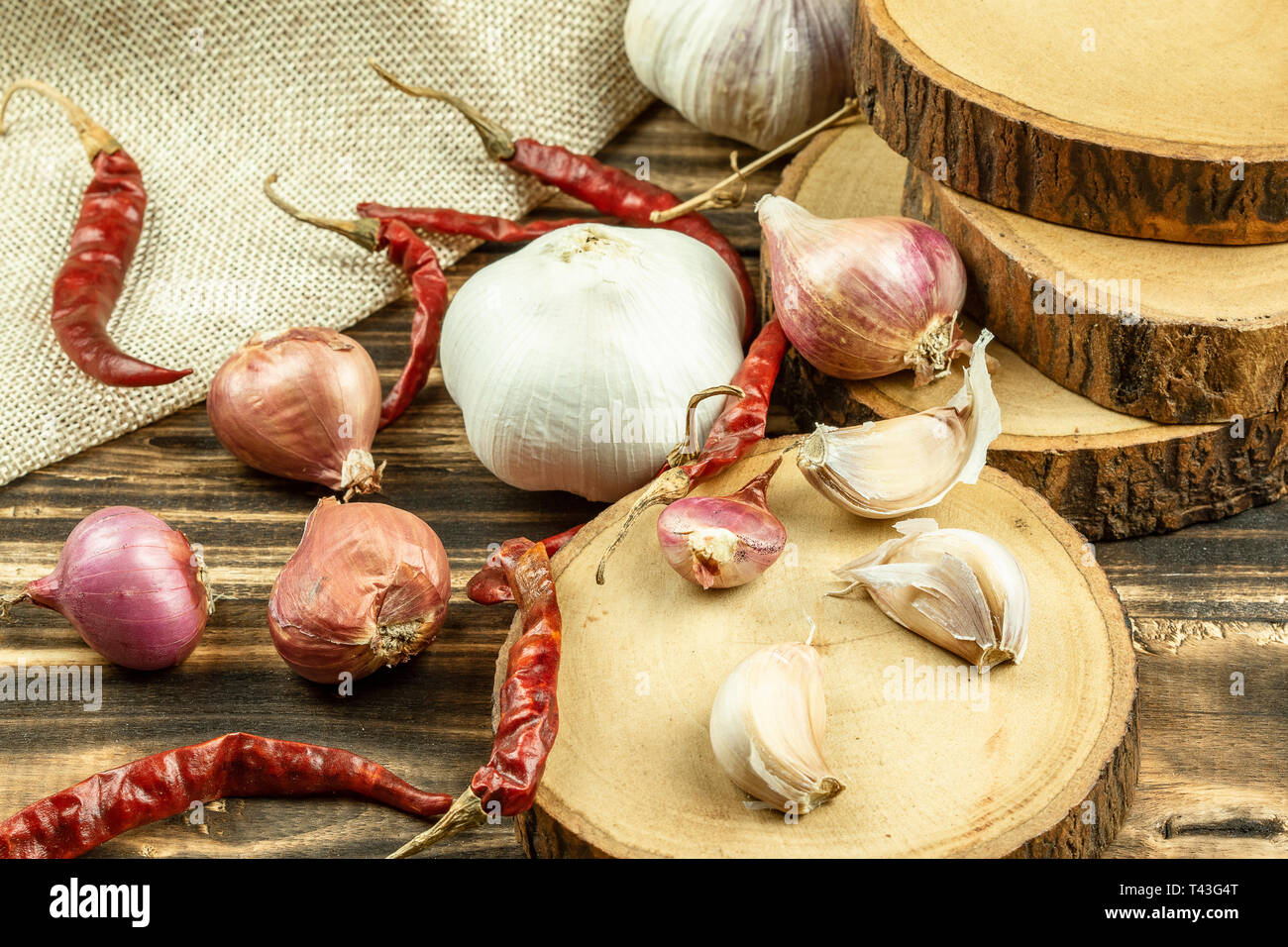 Close up of shallot, garlic, dried red chilli on wooden table background. Stock Photo