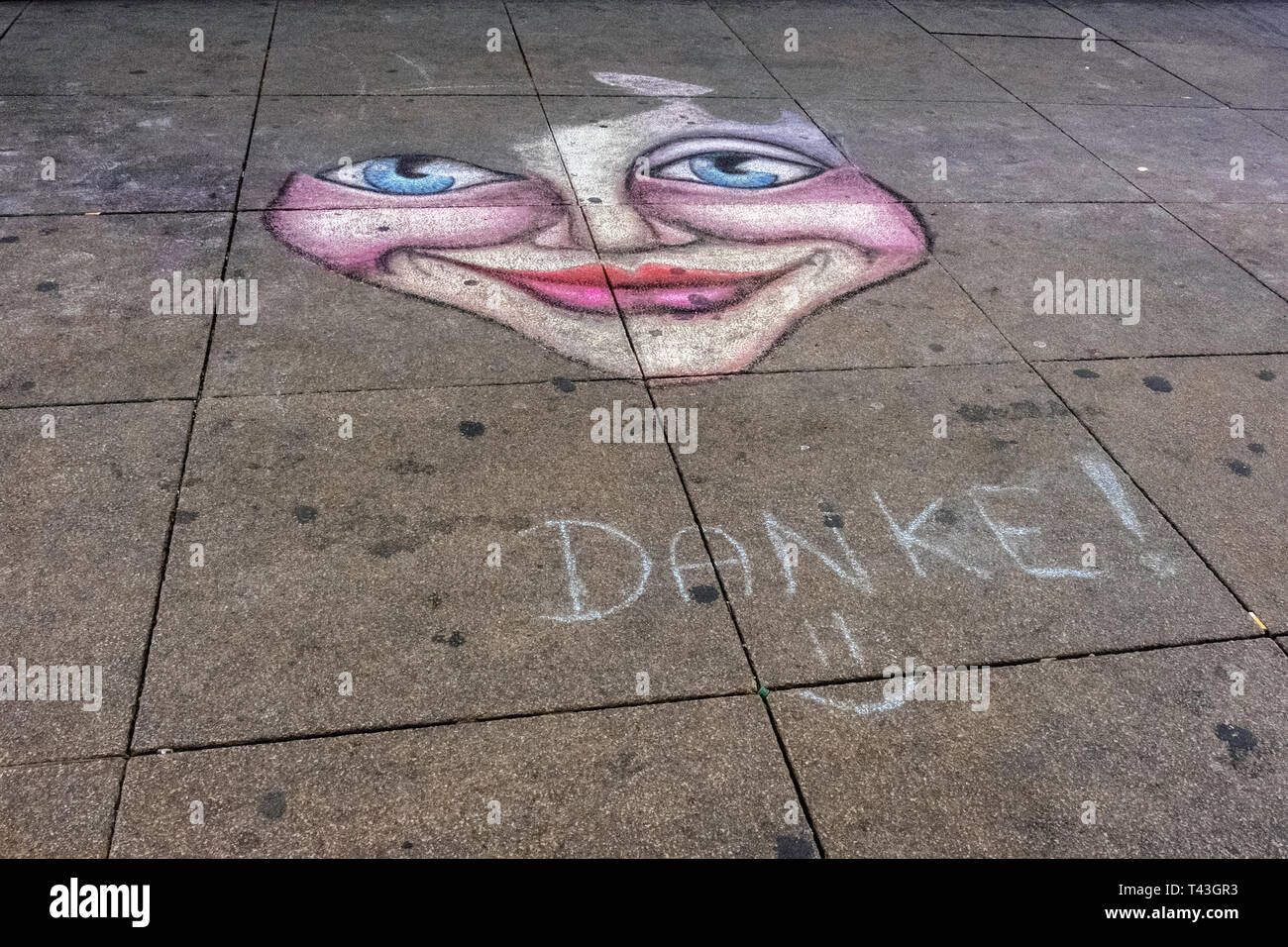 berlin Mitte. Chalk drawing of a smiling face on pavement. Transient, impermanent, short-lived artwork Stock Photo