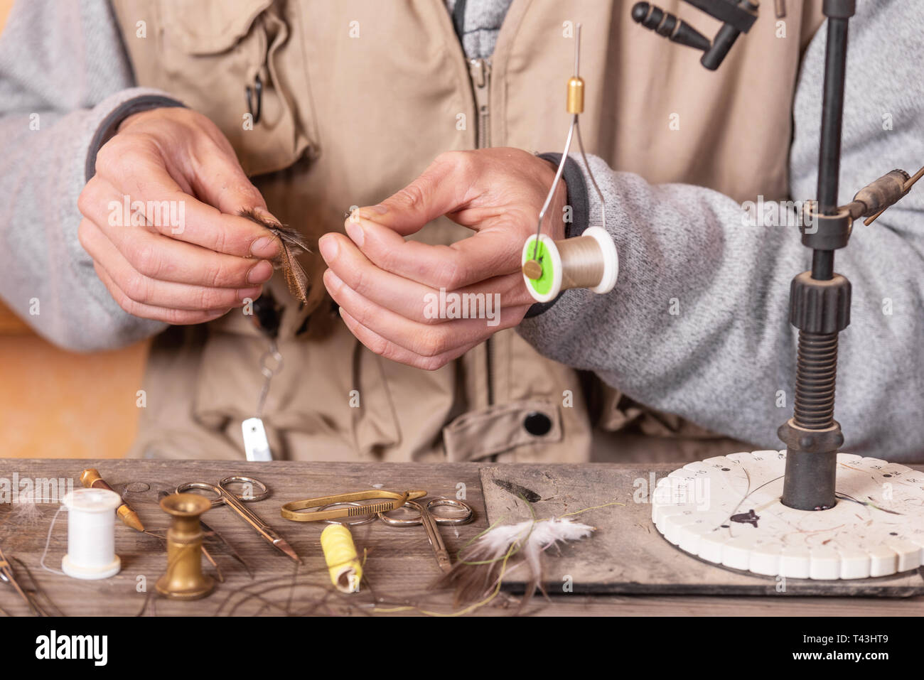 Man making trout flies. Fly tying equipment and material for fly