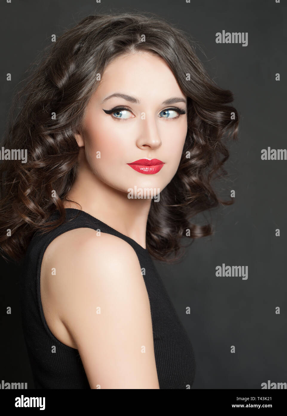 Attractive woman portrait. Perfect model with makeup and curly hair Stock Photo