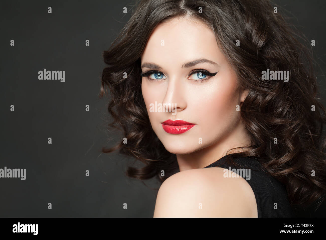 Beautiful woman with makeup and dark curly hair portrait Stock Photo