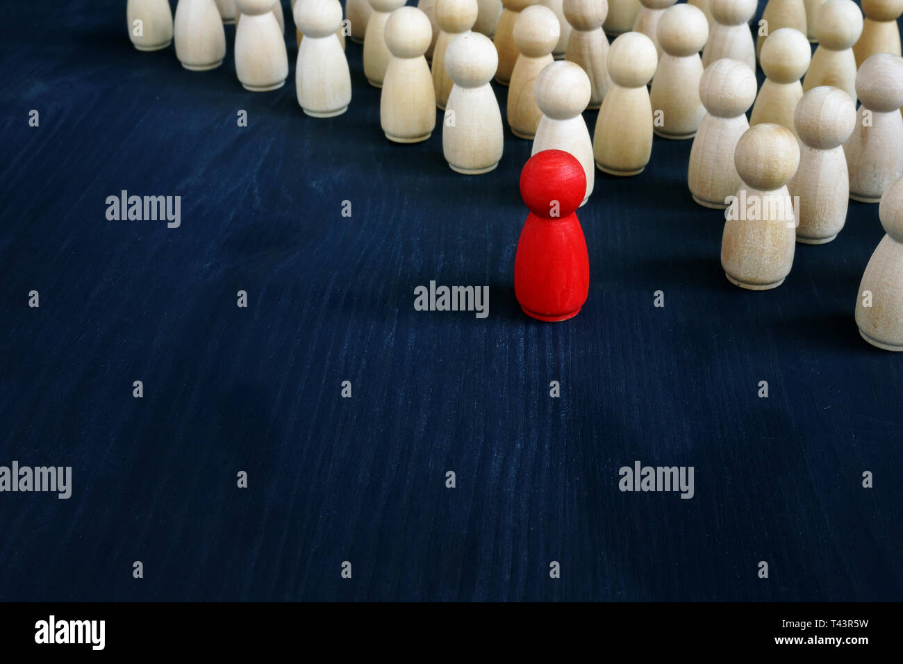 Stand out from the crowd concept. Uniqueness and individuality. Line of figurines. Stock Photo