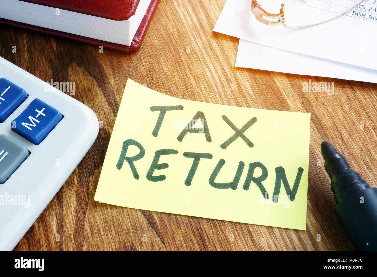 Tax return. Memo with accounting report on a desk. Stock Photo