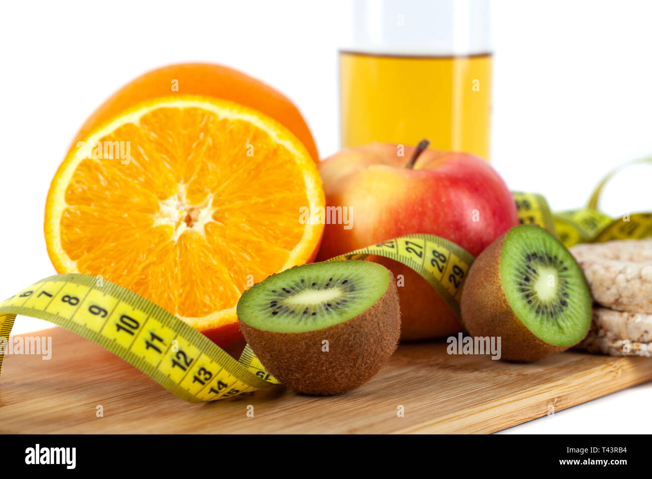 Apple, orange, kiwi with measure tape on white background, healthy diet
