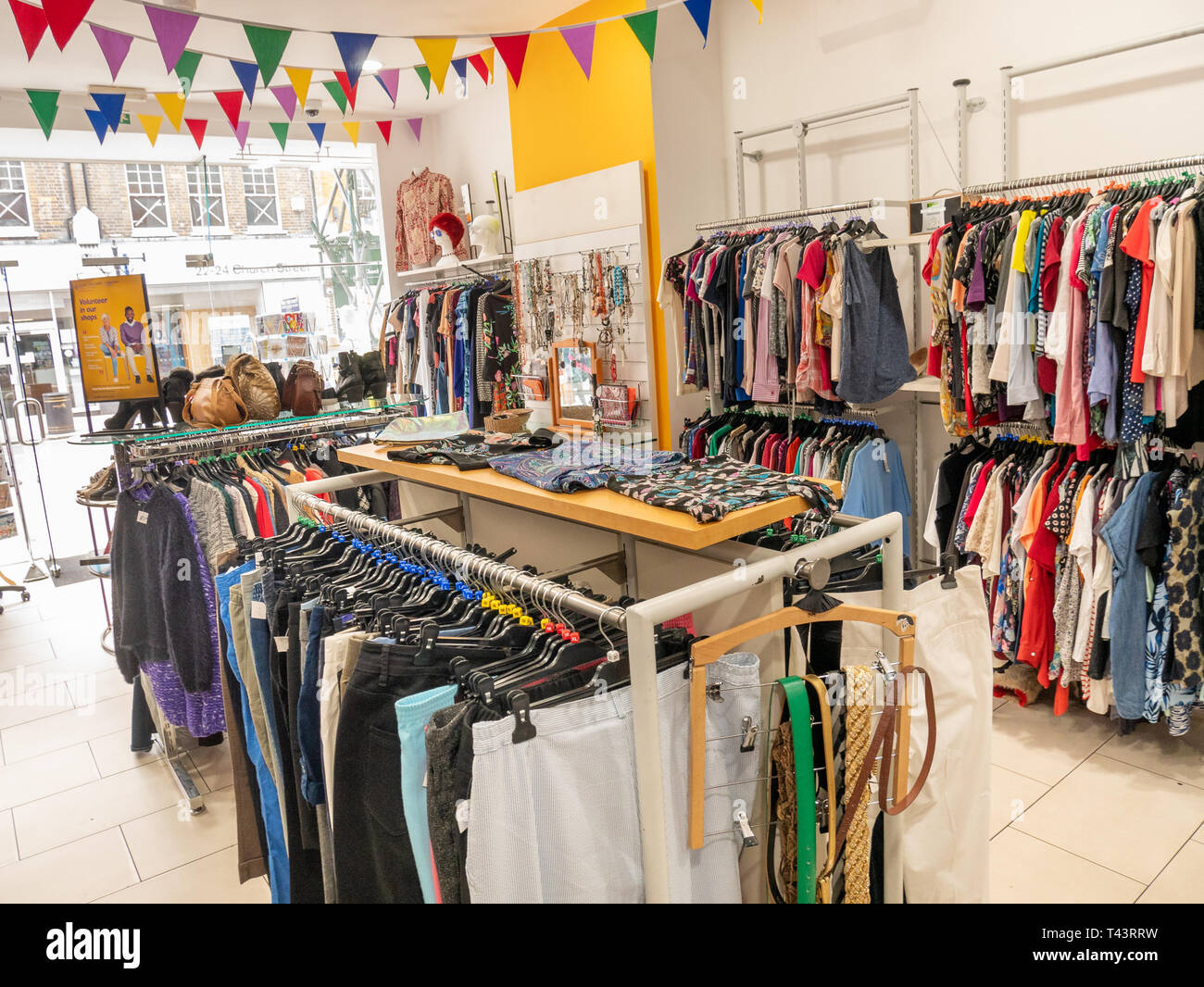 Clothes rails in charity shop, London, UK Stock Photo