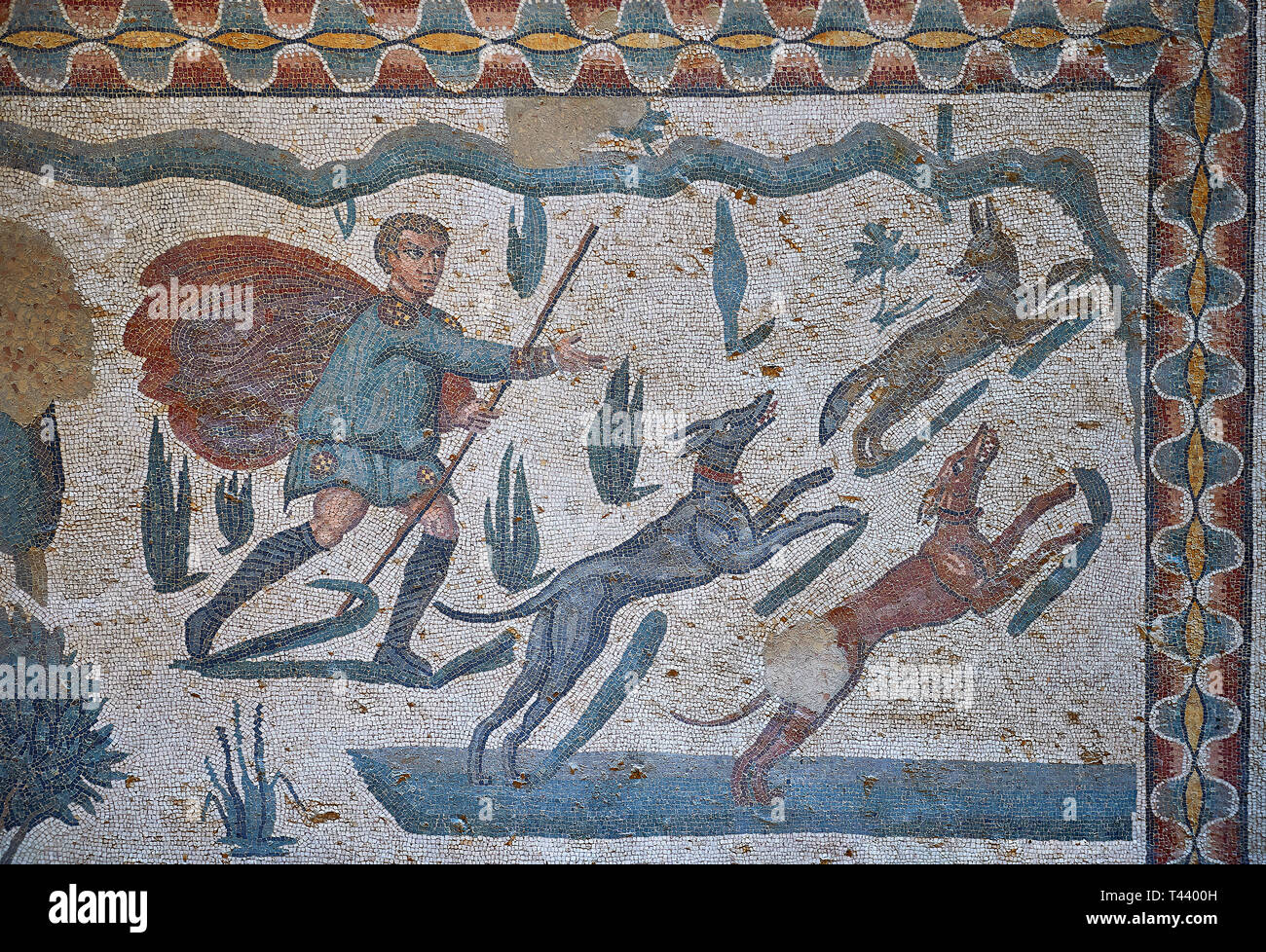 Hunter with dogs. Roman mosaic floor of the Room of The Small Hunt, no 25 - Roman mosaics at the Villa Romana del Casale ,  circa the first quarter of Stock Photo