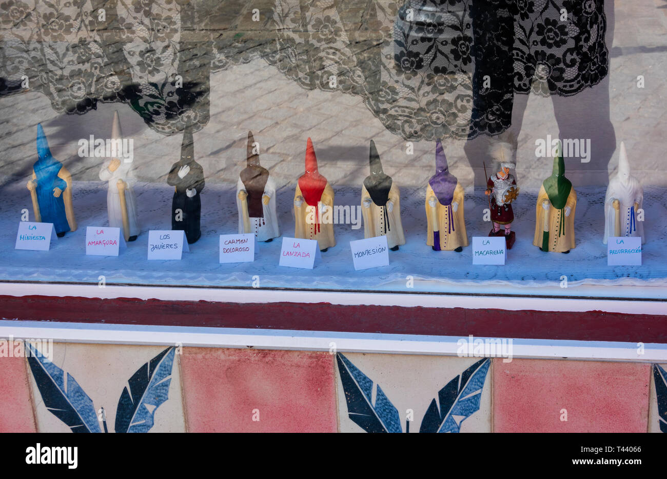 Tiny sculptures of the Capirote in a shop window in Seville Stock Photo