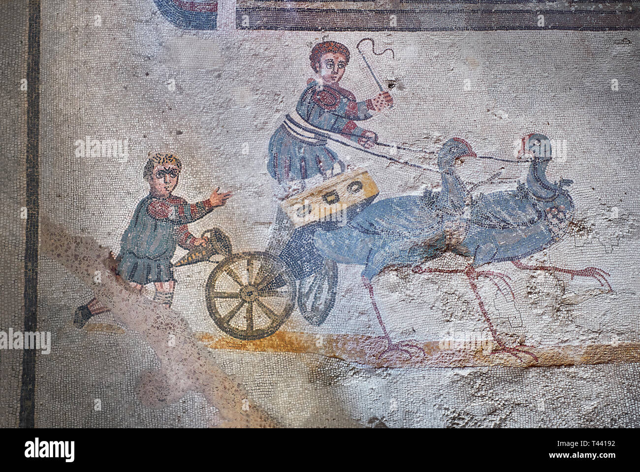 Close up picture of the Roman mosaics of the room of the Small Circus depicting Roman boys riding small chariots pulled by birds in a small circus, Th Stock Photo