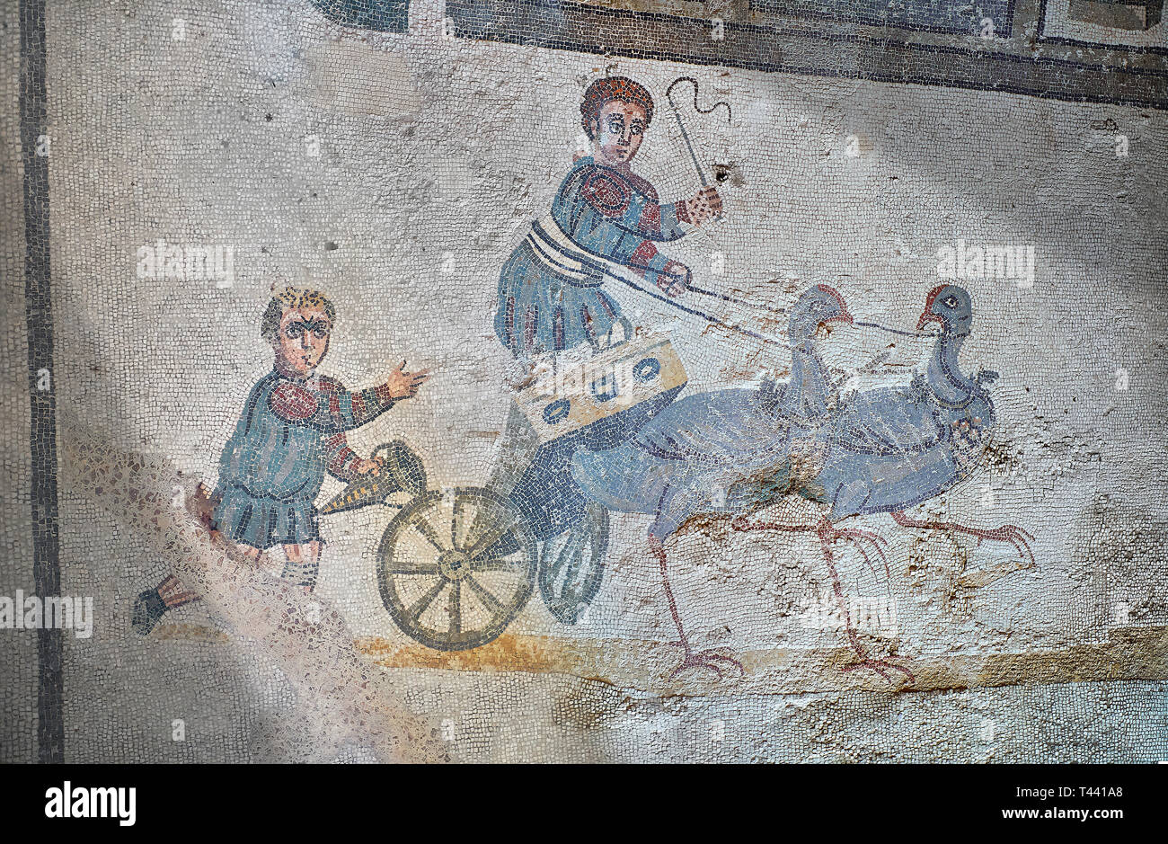Close up picture of the Roman mosaics of the room of the Small Circus depicting Roman boys riding small chariots pulled by birds in a small circus, Th Stock Photo