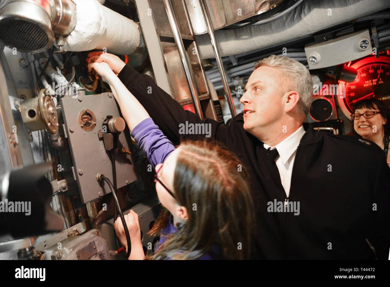 PITTSBURGH, Pa. (Mar. 14, 2019) Senior Chief Dave Jackson, from Denver, Colorado, and his daughter show visitors onboard the USS Requin (SS 481) how to use the dive alarm. Jackson is stationed on the nuclear-powered Los Angeles-class, fast-attack submarine USS Pittsburgh (SSN 720) and visited the Requin at the Carnegie Science Center with other crewmembers. Pittsburgh crewmembers are participating in various events around Pittsburgh to bring awareness to the U.S. Navy's mission. The Navy's fast-attack submarines are designed to seek and destroy enemy submarines and surface ships; deliver missi Stock Photo
