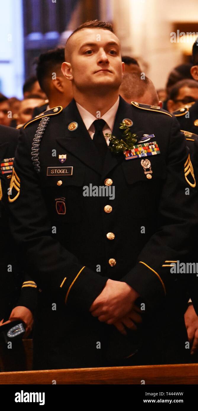 New York Army National Guard Staff Sgt. Mitchell Stogel listens to Mass in St. Patick’s Cathedral, in New York on March 16, 2019. Stogel was attending Mass at the Cathedral with the rest of 1st Battalion, 69th Infantry Regiment, prior to marching in the St. Patrick's Day Parade. The 1st Battalion, 69th Infantry traditionally leads the world's largest St. Patrick's Day Parade. Stogel wears a sprig of boxwood on his uniform because Irish-American Soldiers of the 69th Infantry marked their uniforms that way during the Battle of Fredricksburg in 1863. (N.Y. Army National Guard Stock Photo