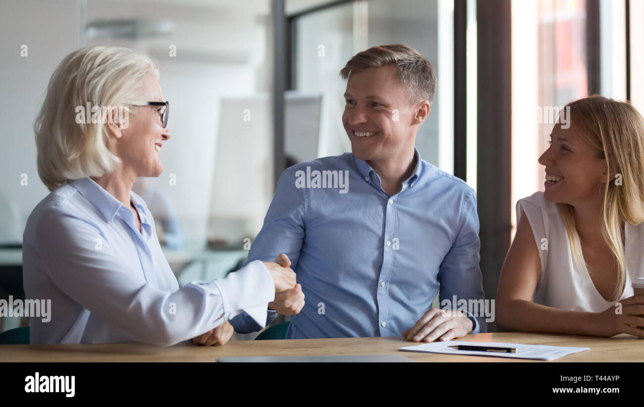 Happy young couple handshake broker making insurance investment bank ...