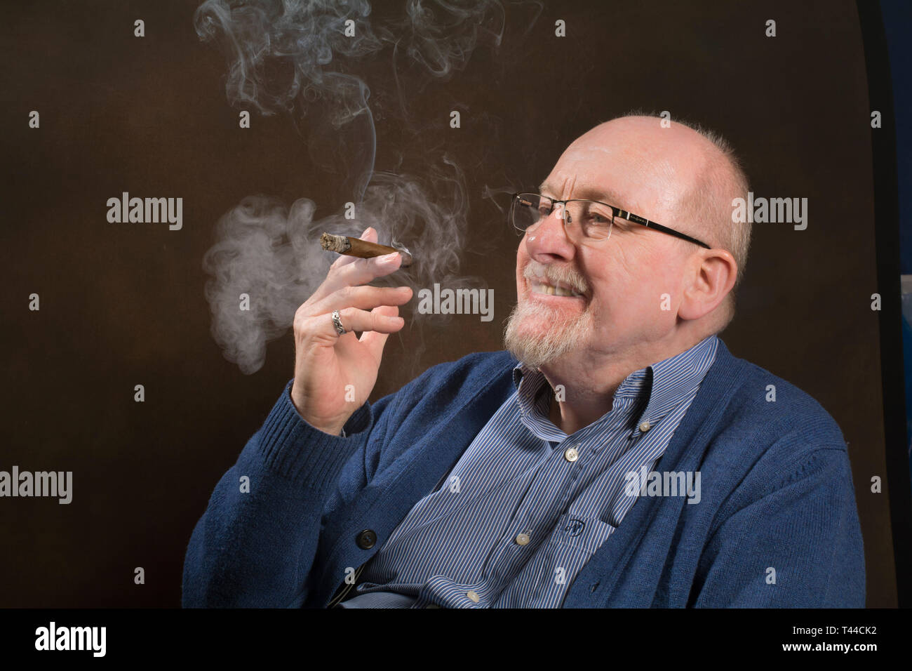 An older man enjoying smoking a good cigar Stock Photo