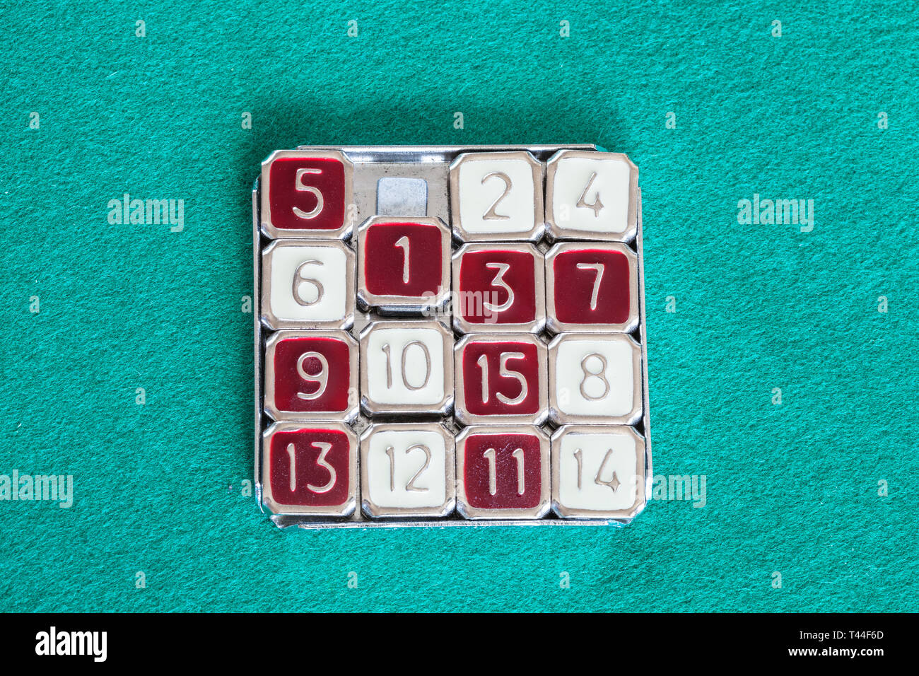 top view of 15-puzzle (magic 15) sliding puzzle game on green baize table Stock Photo