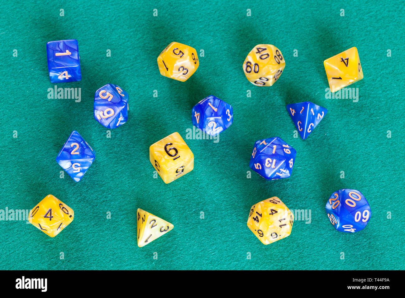 two sets of polyhedral dices for Dungeons and Dragons board game playing on green baize table Stock Photo