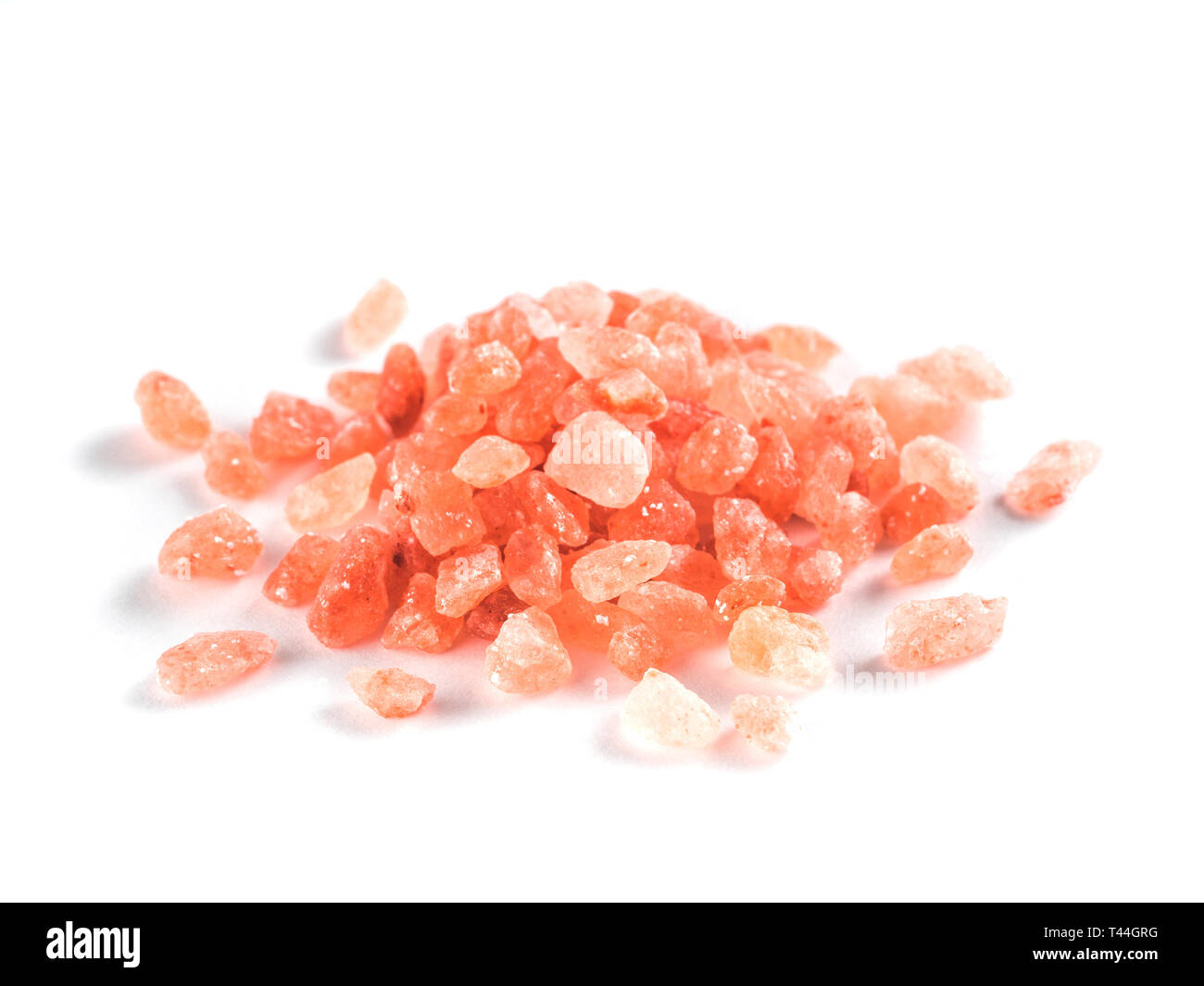 Himalayan pink salt in crystals on white background. Heap of pink salt isolated with clipping path. Stock Photo