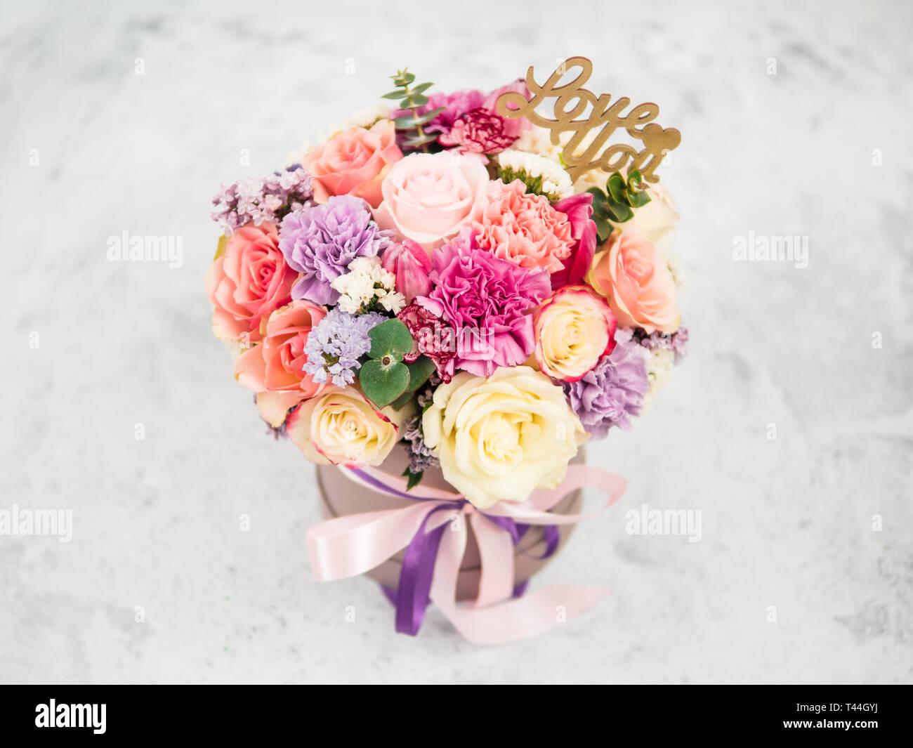 Beautiful bouquet with roses, dianthus, carnation bush, limonium, lilac and tulip. Bouquet with different flowers. Shallow DOF, copy space. Top view. Stock Photo