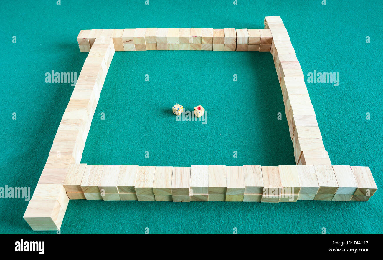 beginning of play in mahjong, tile-based chinese strategy board game on green baize table Stock Photo