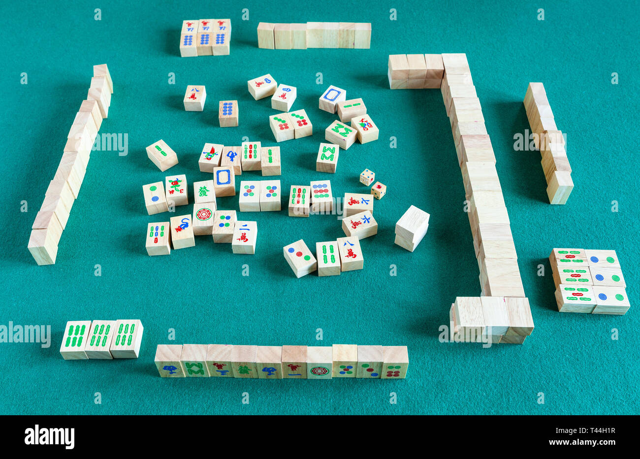 above view of gameboard of mahjong game, tile-based chinese strategy board game on green baize table Stock Photo