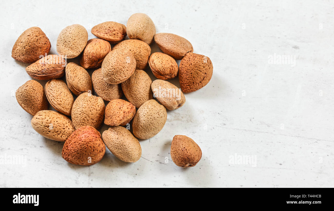 Whole almonds in shell, on white board. Stock Photo
