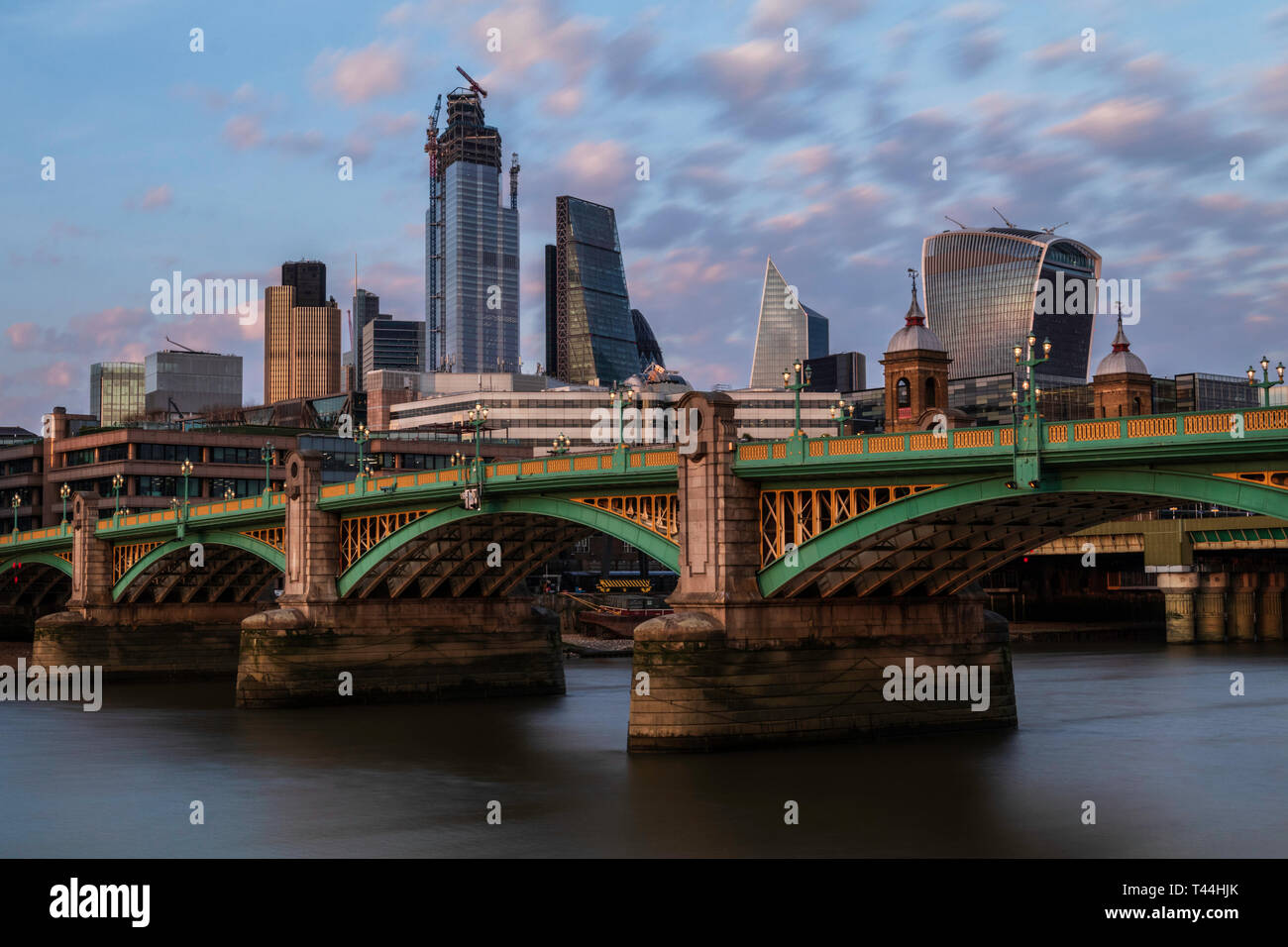 Southwark bridge at riverside in London with some cityskape adn skysrapers at the background. Stock Photo