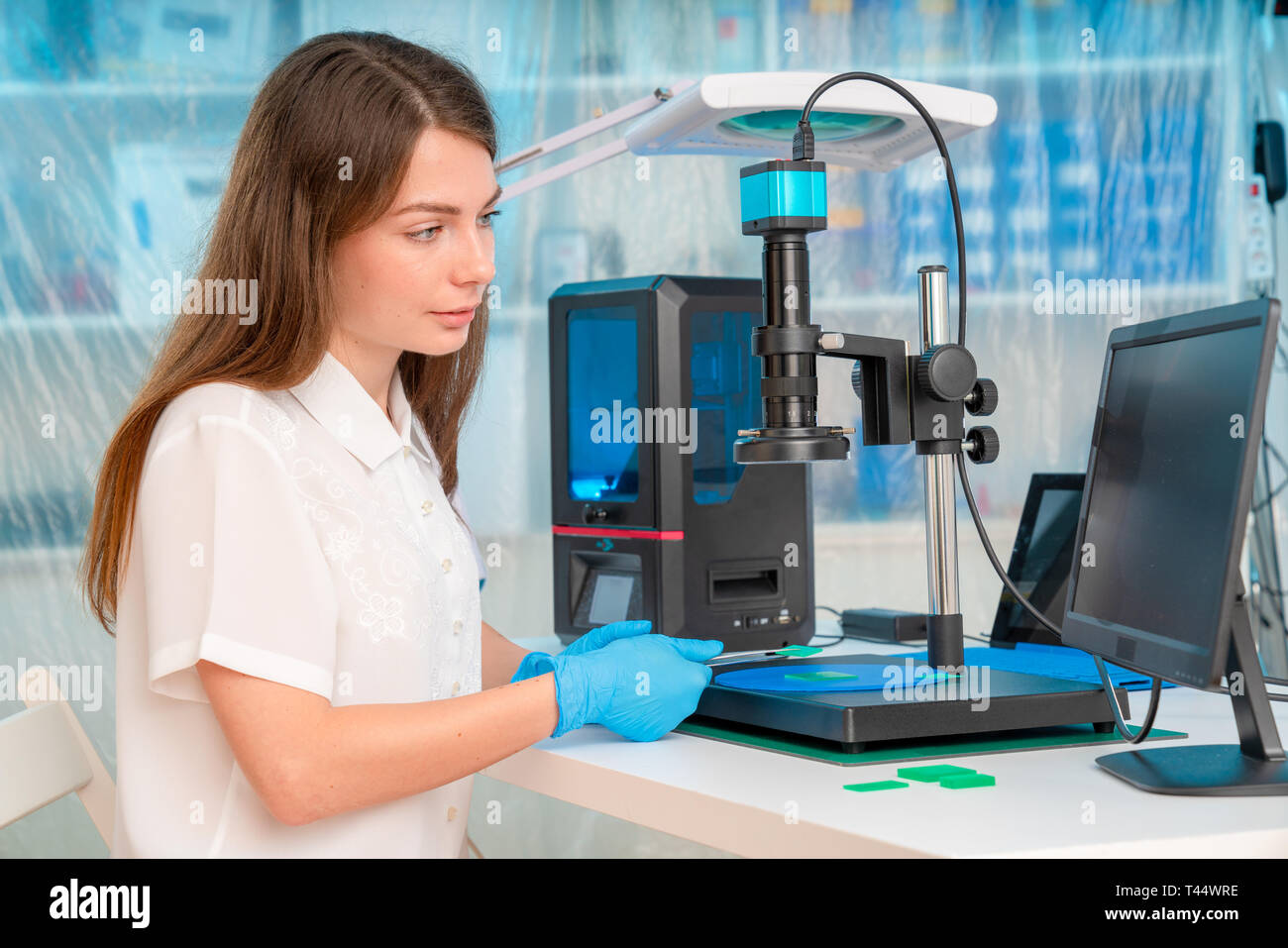 Woman worker in control of Resin LCD / DLP / SLA 3D Printer in technology lab Stock Photo